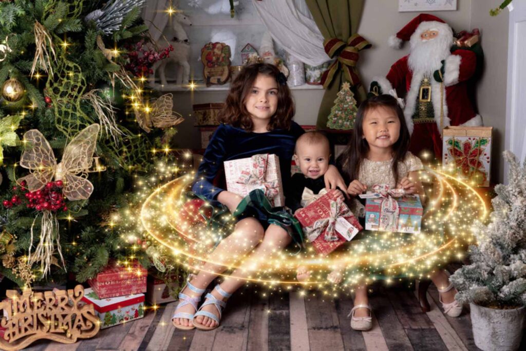Christmas themed portrait of siblings posed beside a christmas tree with a light flare effect
