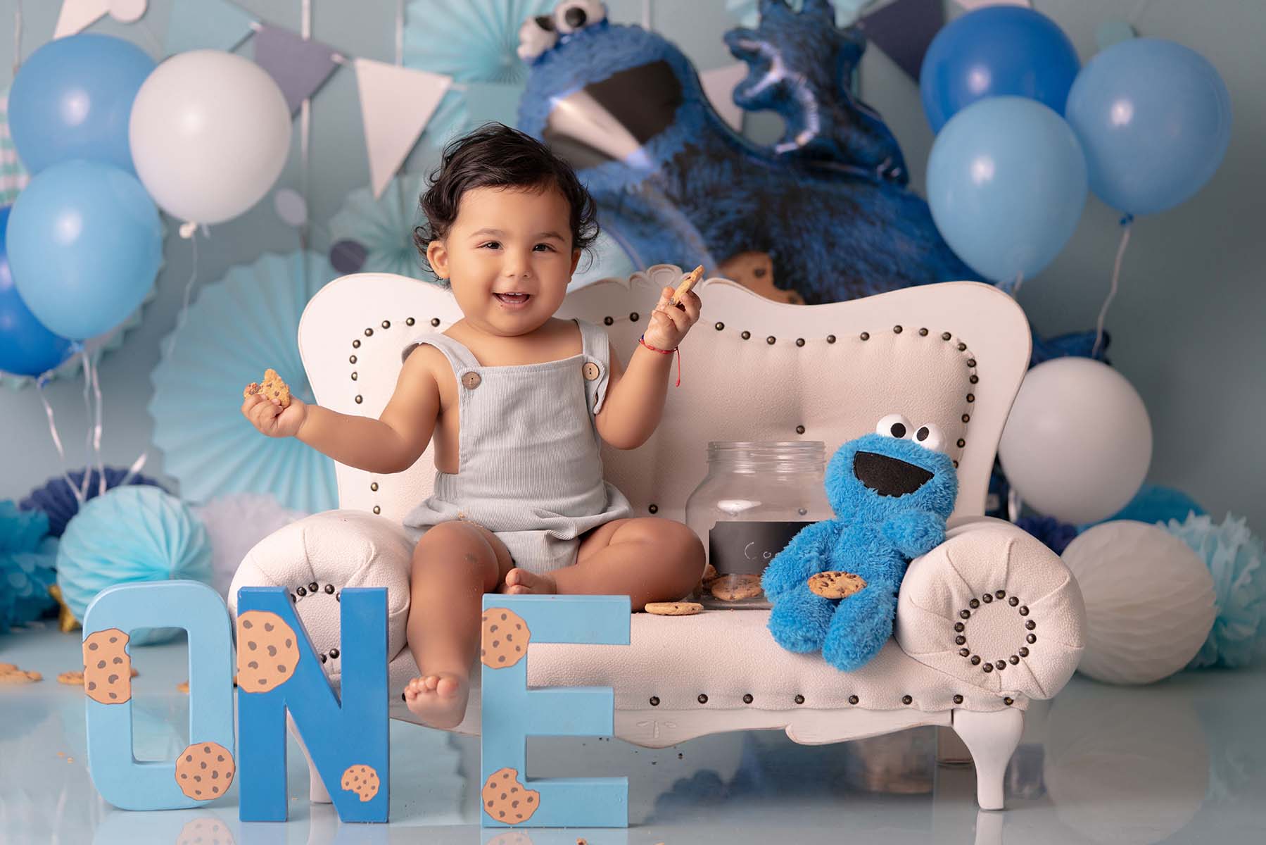 Cookie monster themed children's portrait with a child sitting on a couch prop holding cookies