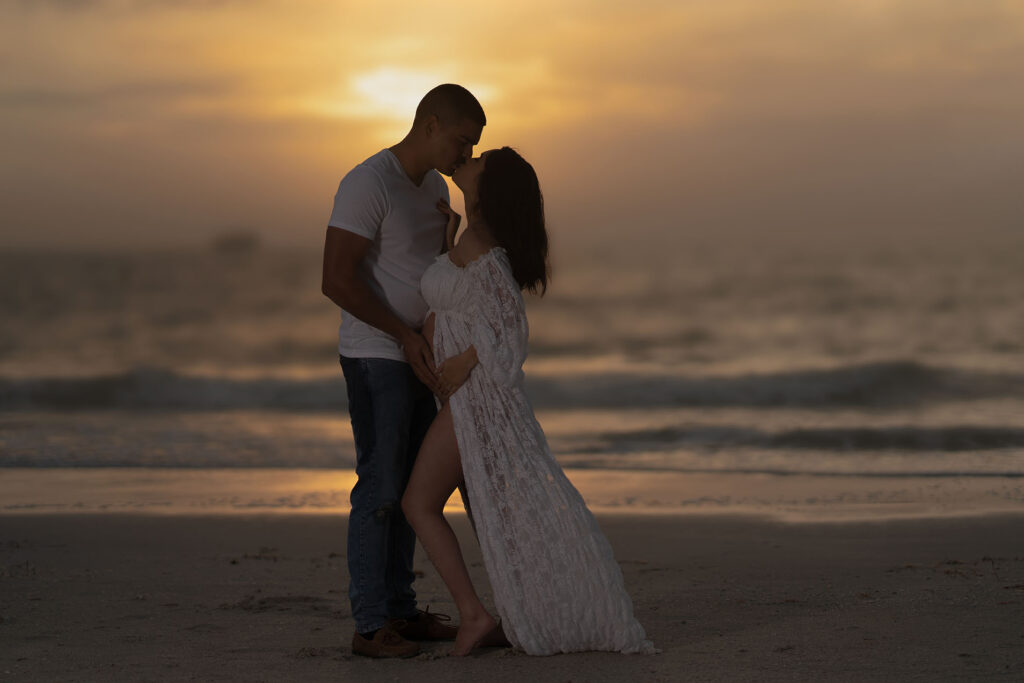 Sunset maternity couples session of a couple on a beach