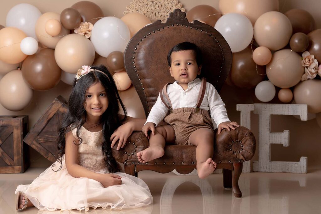 Portrait of siblings in a neutral and brown set with balloons