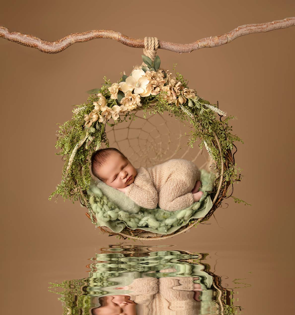 Newborn portrait of baby in a swing woven with leaves and flowers