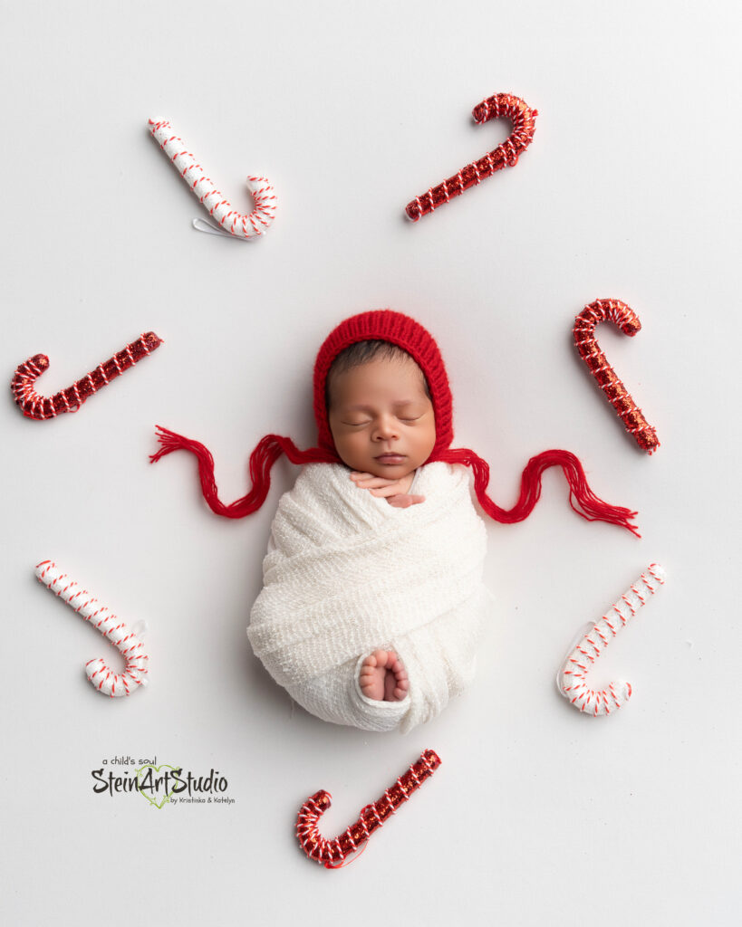 Luxury newborn photoshoot in Orlando featuring baby in red and gold Christmas theme
