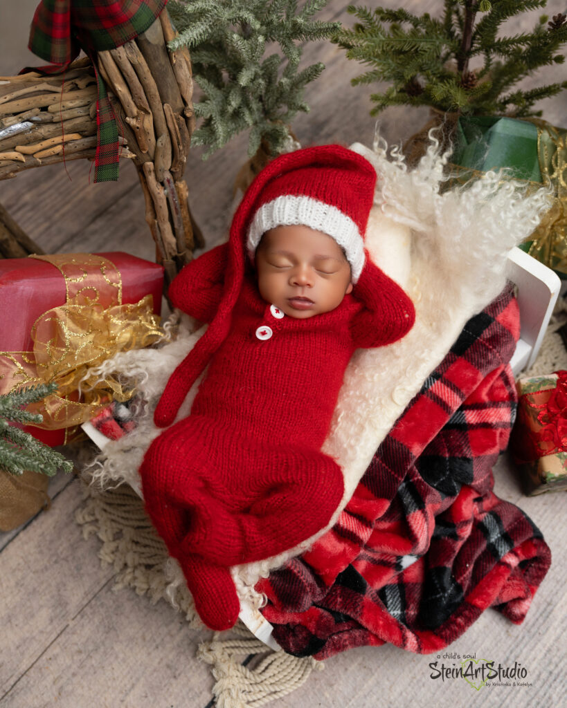 Luxury newborn photoshoot in Orlando featuring baby in red and gold Christmas theme